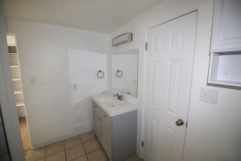 A room with wooden flooring and a window with blinds.