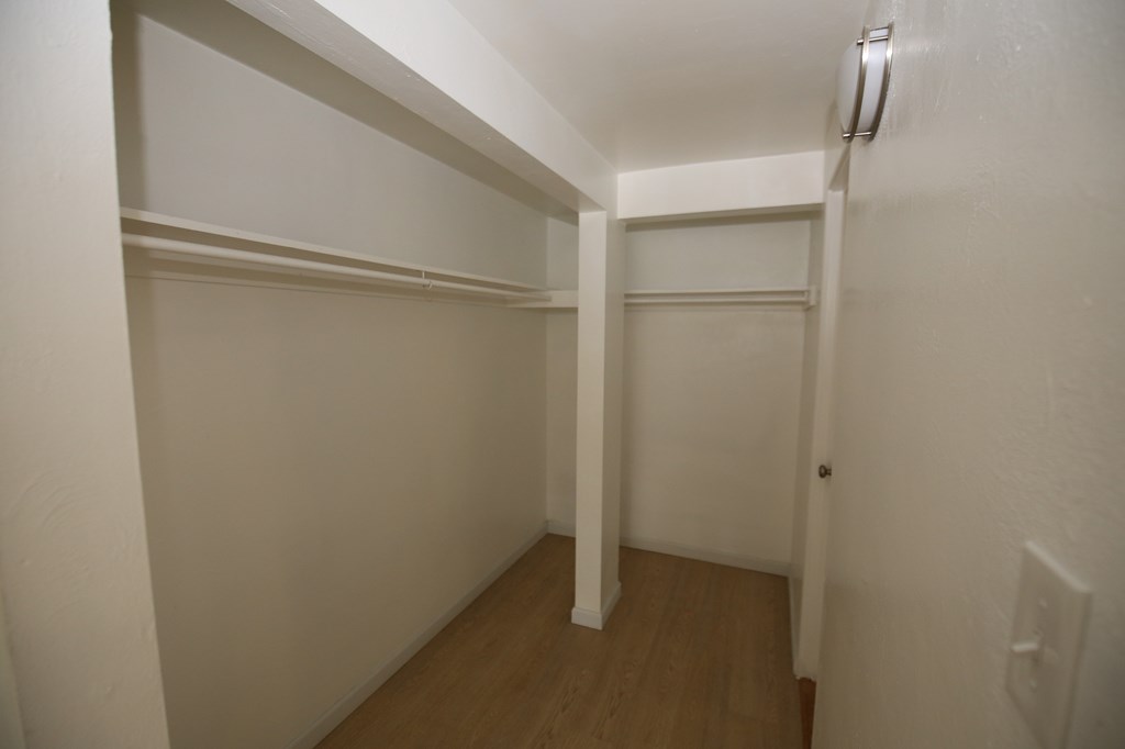 A white hallway with wood floors and white walls.