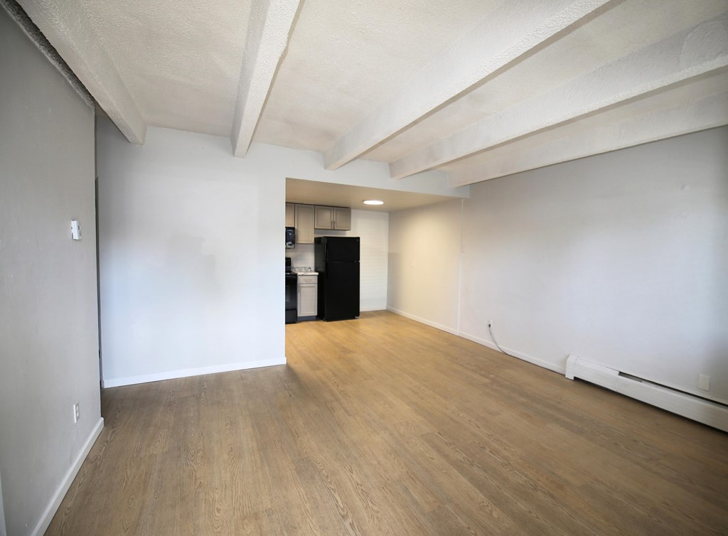 A room with wooden flooring and white walls.