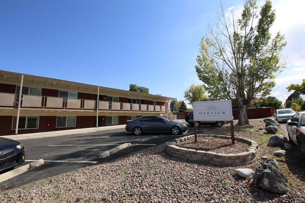 A parking lot with a sign that says Oakview in front of a building.