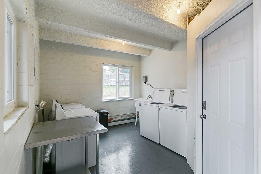 A kitchen with white cabinets and a window.