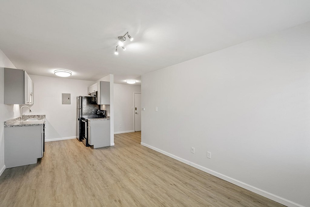 A kitchen area with a sink, refrigerator, and a microwave.
