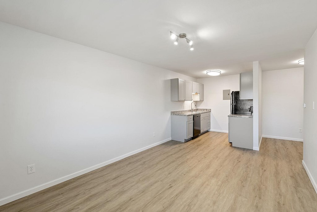 A kitchen area with a refrigerator, microwave, and cabinets.