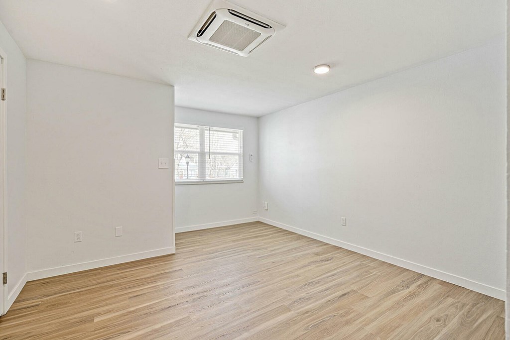 A room with wooden flooring and a window.