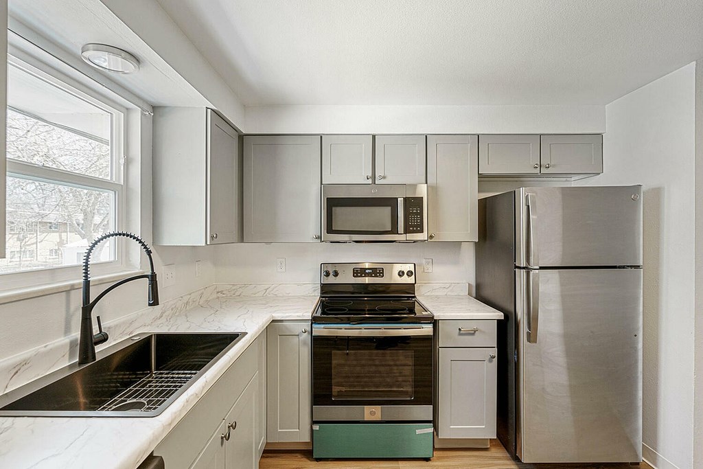 A modern kitchen with stainless steel appliances and white cabinets.