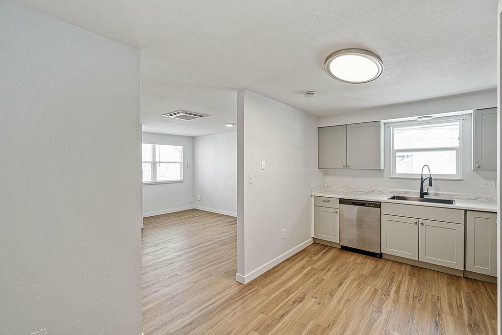 A kitchen with wooden floors and white walls.