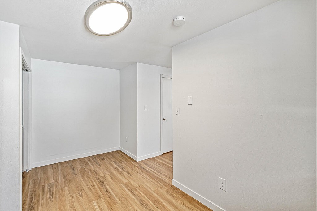 A room with a wooden floor and white walls.