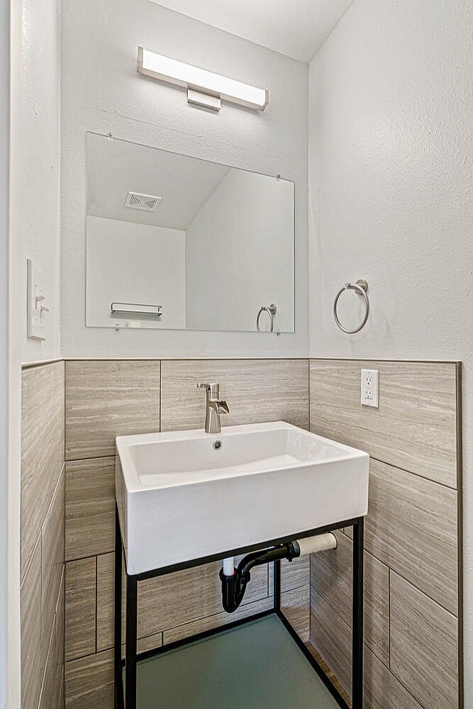 A bathroom with a white sink and a mirror above it.