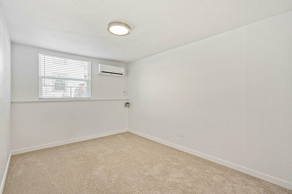 A room with a window and an air conditioner.