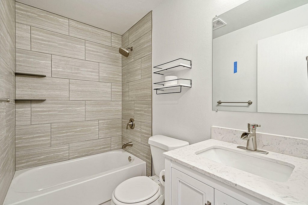 A white bathroom with a tub, toilet, and sink.