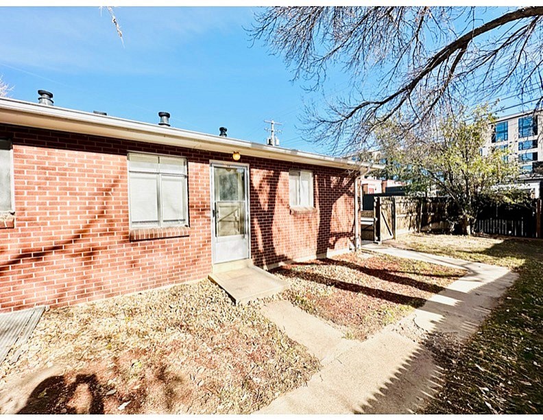 A red brick house with a white door and windows.