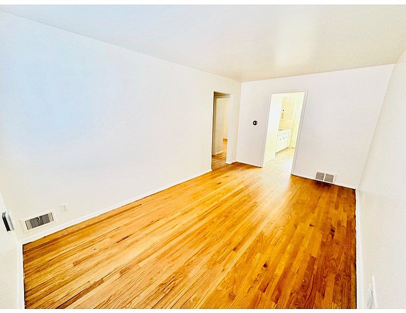 A room with wooden floors and white walls.