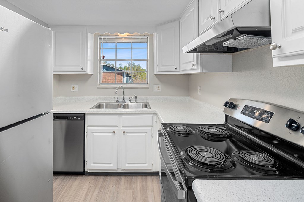 A kitchen with white cabinets and a black stove top oven.