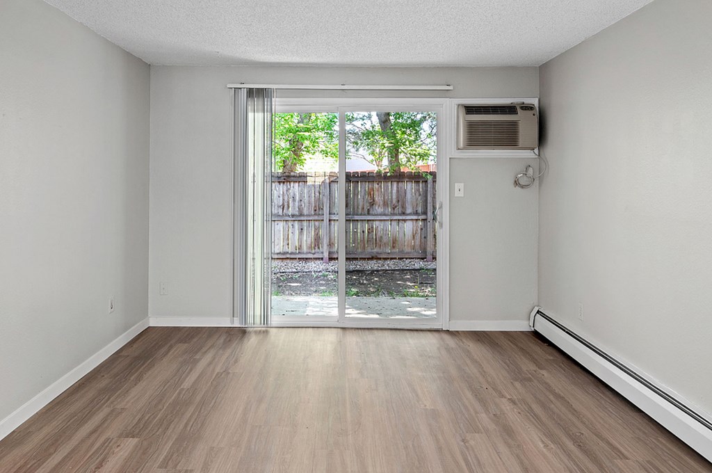 A room with a sliding glass door leading to a backyard.