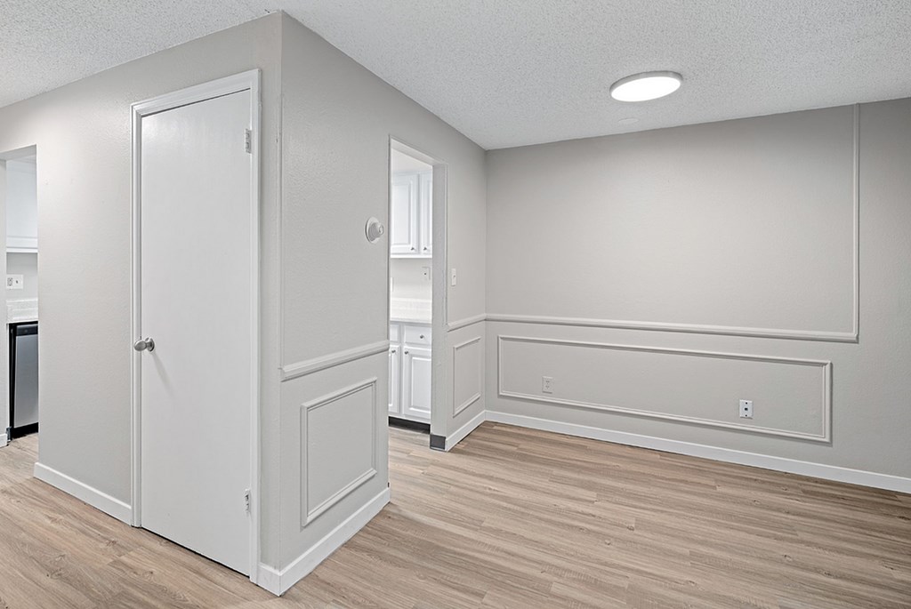 A white door is in a room with wood flooring.