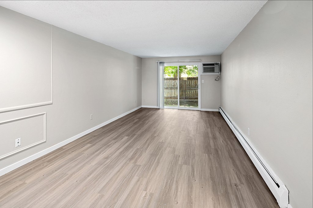 A room with light wood flooring and white walls.