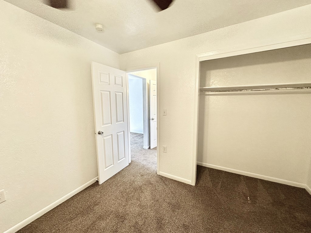 A room with a carpeted floor and a white door.