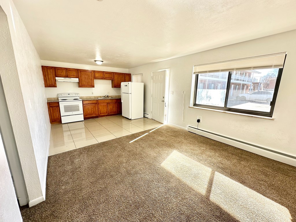 A kitchen with white appliances and brown cabinets.