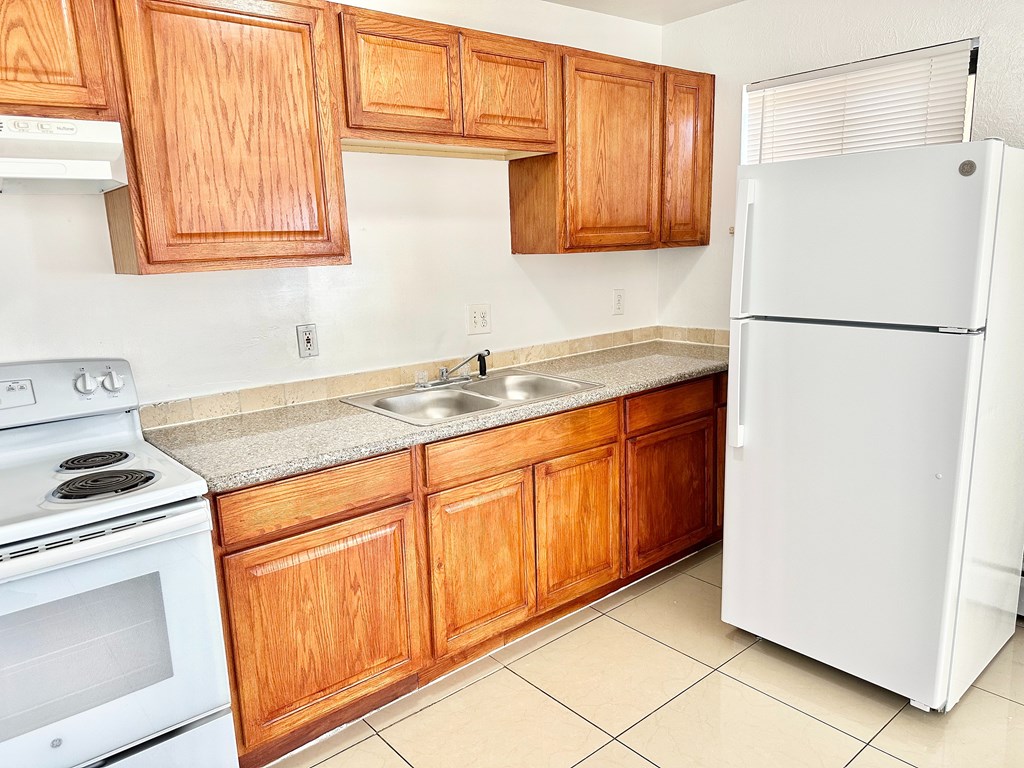 A kitchen with wooden cabinets and a white refrigerator.