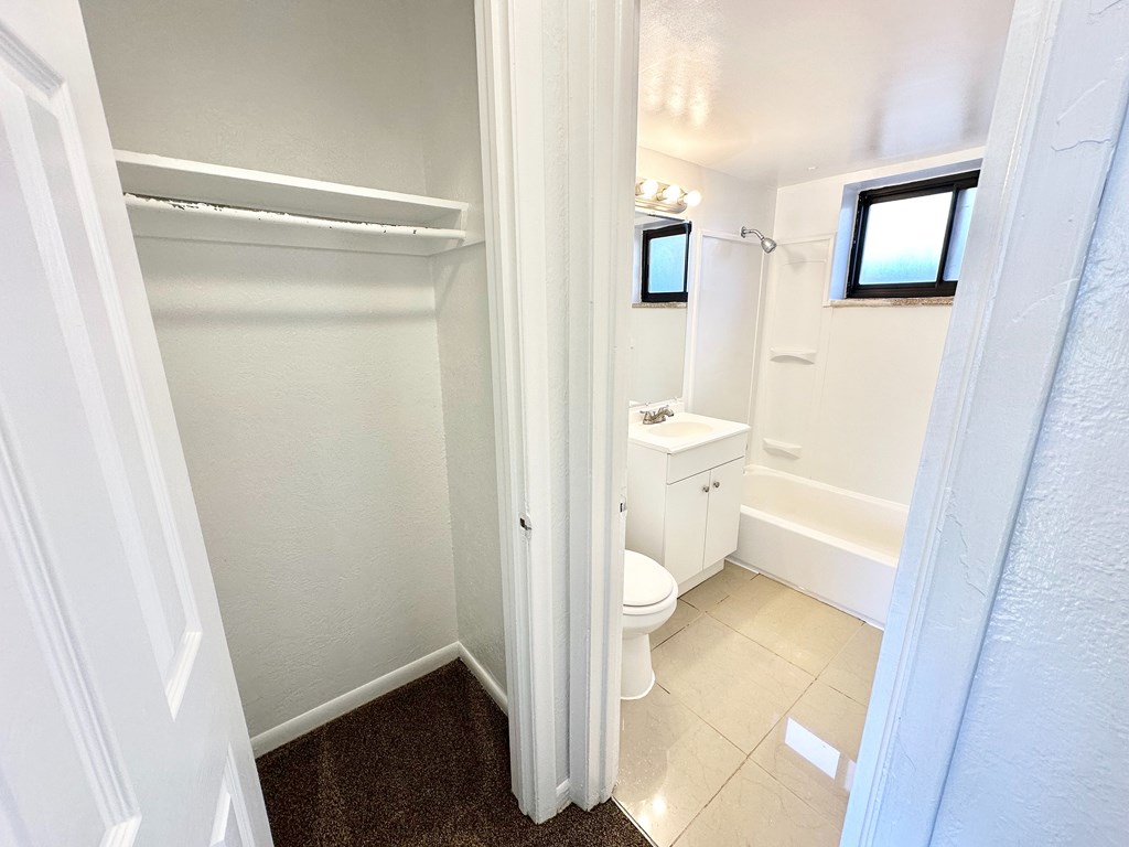 A white bathroom with a toilet, sink, and bathtub.