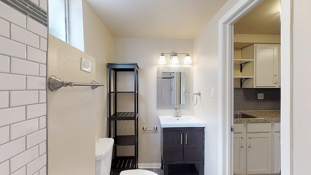 A small bathroom with a toilet, sink, and a shower stall.