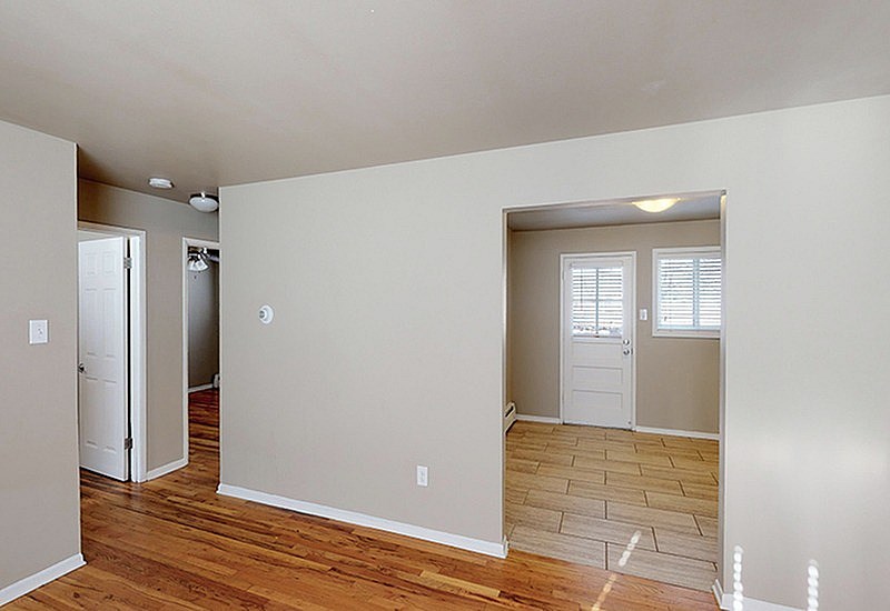 A room with a wooden floor and white walls.