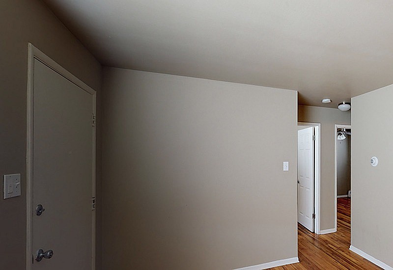 A room with a door and a wall socket.