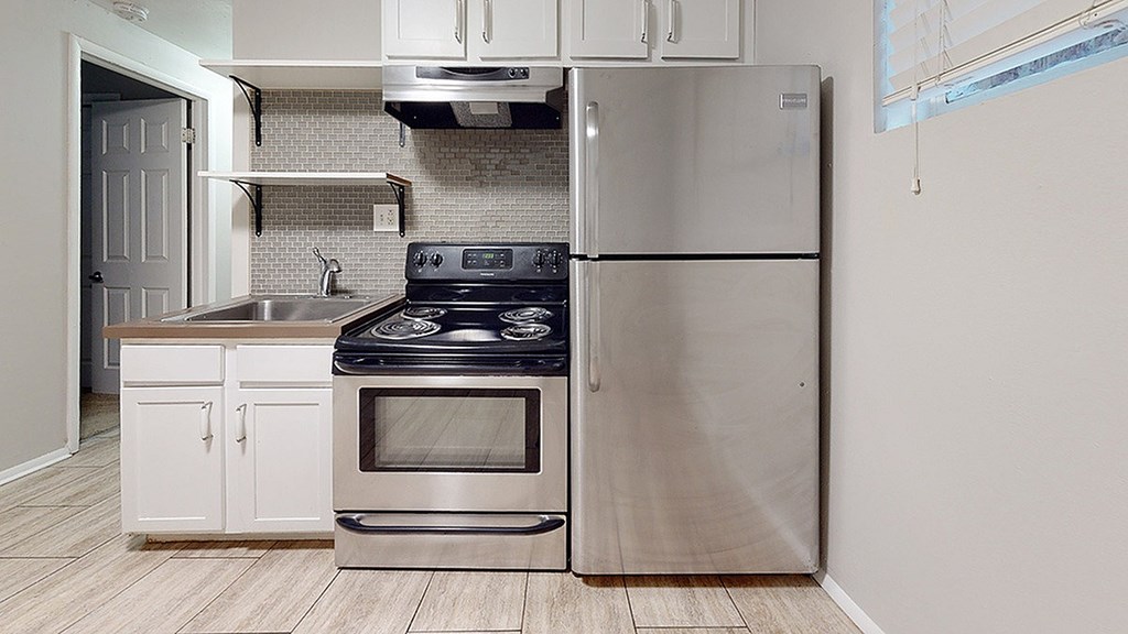 A modern kitchen with a stove, oven, and refrigerator.