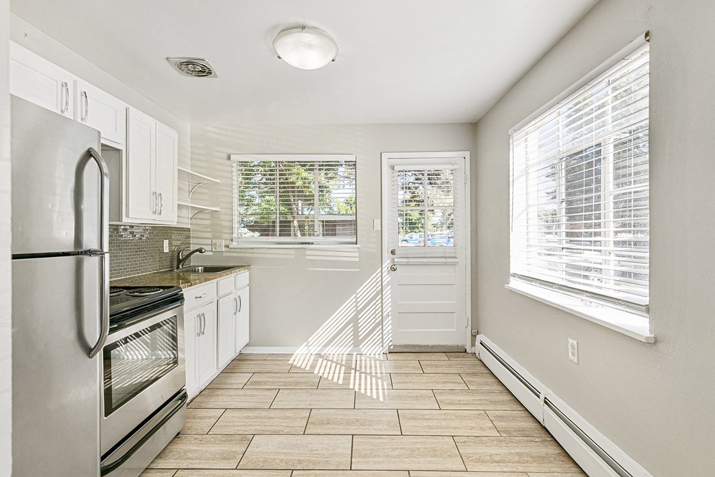 A white bathroom with a shower and a window.
