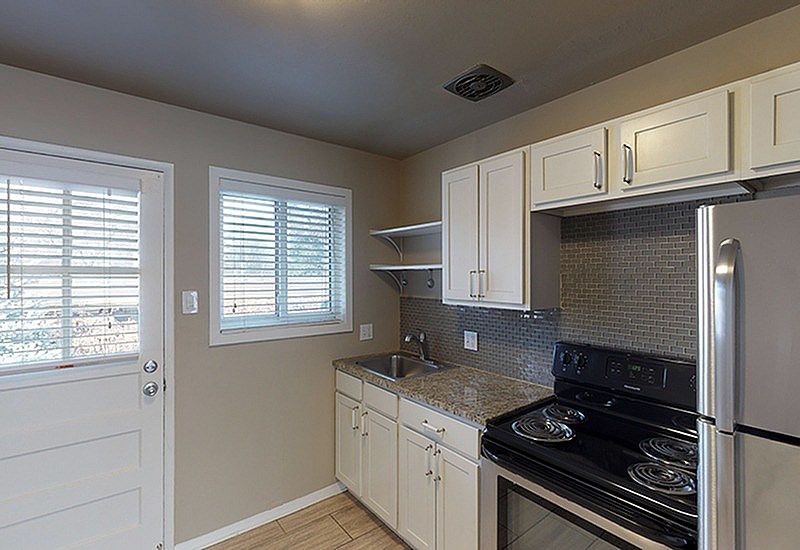 A kitchen with a stove top oven and a refrigerator.