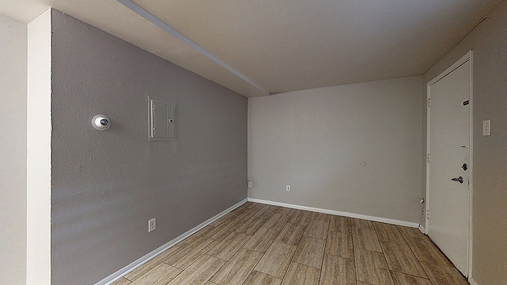 A room with a white door and a grey wall.