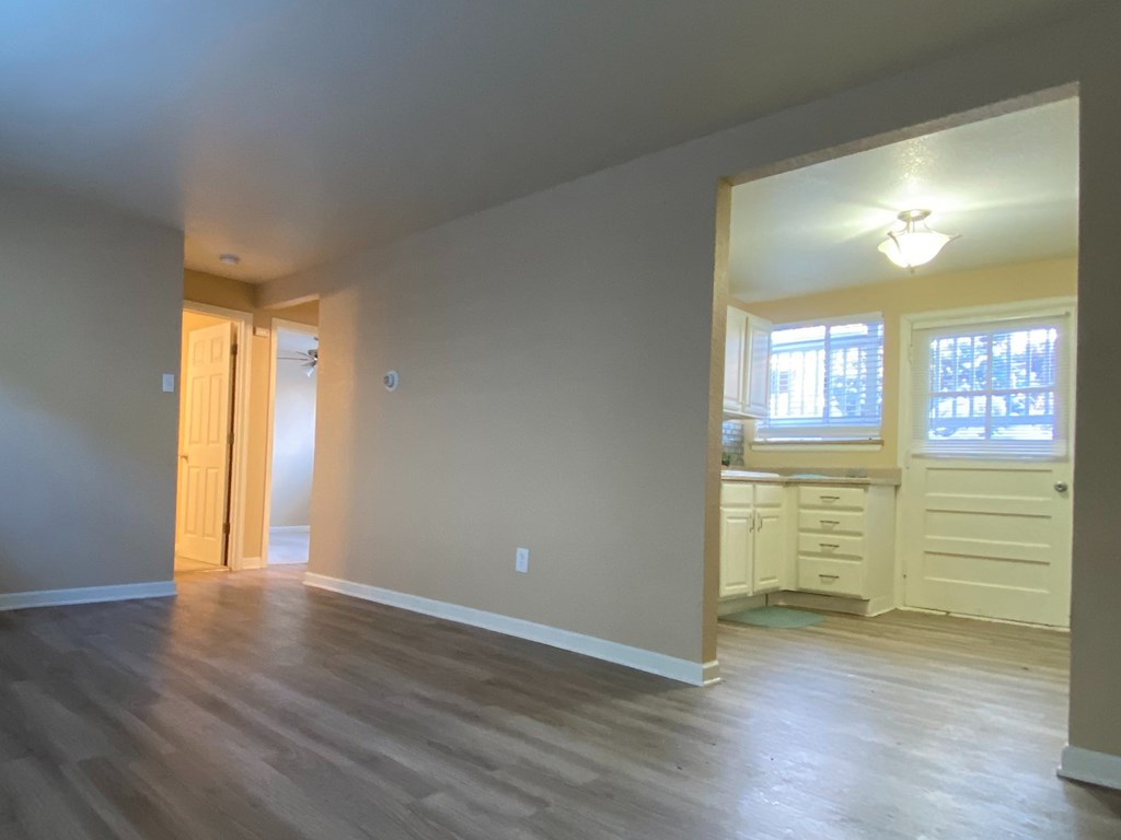 A room with wooden floors and a window with blinds.