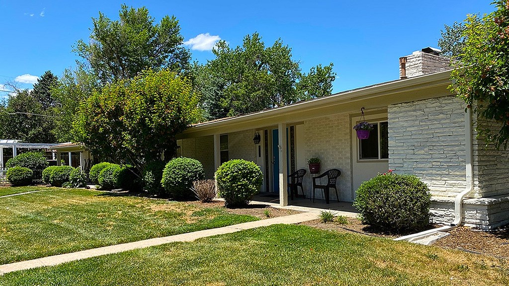 A house with a white front porch and a small garden.