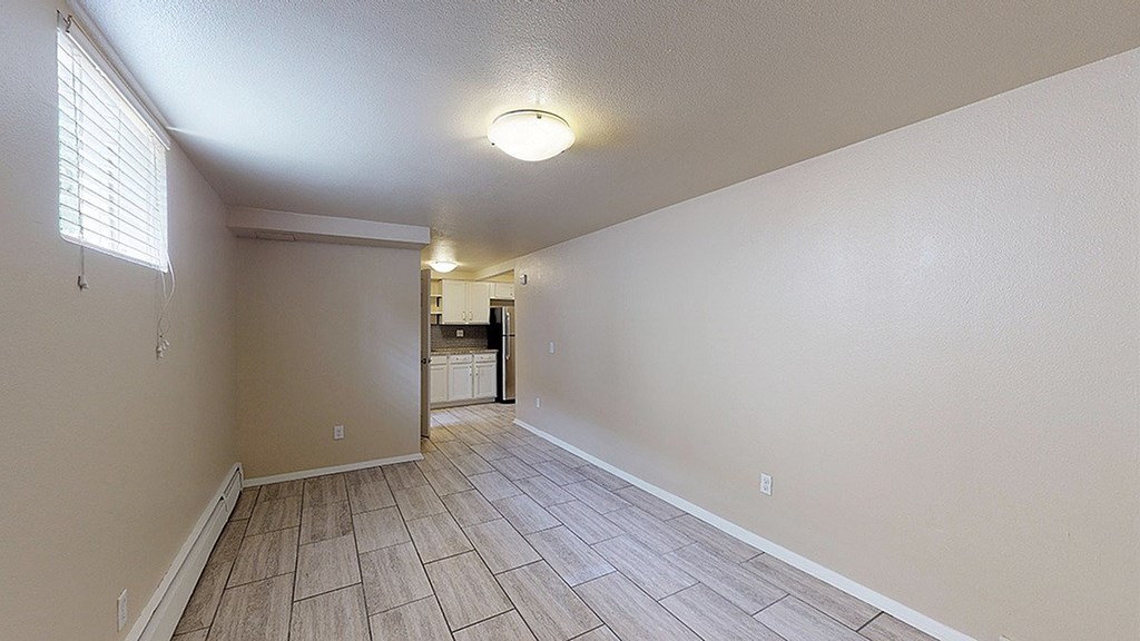 A room with a tile floor and a doorway leading to another room.