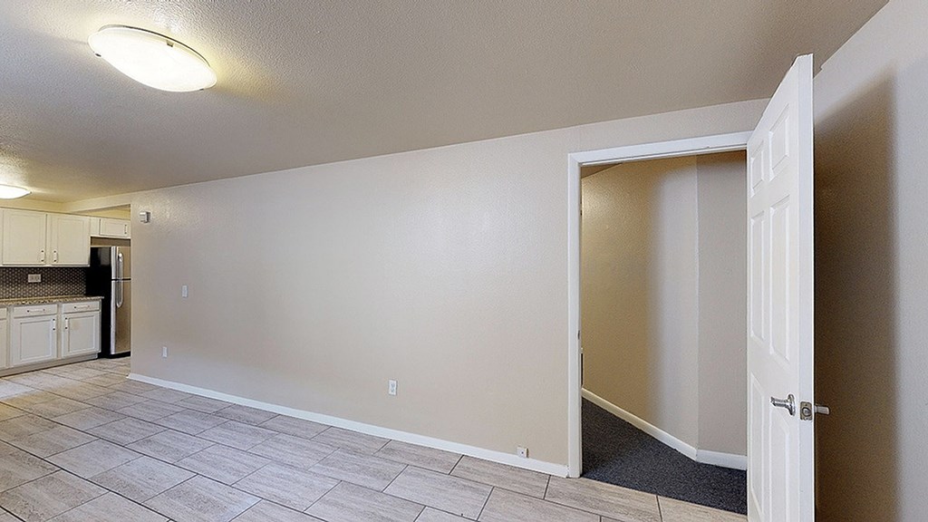 A room with a white door and a grey floor.
