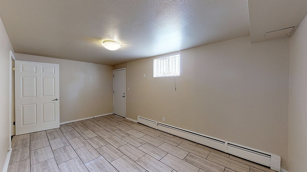 A room with a white door and a window with blinds.
