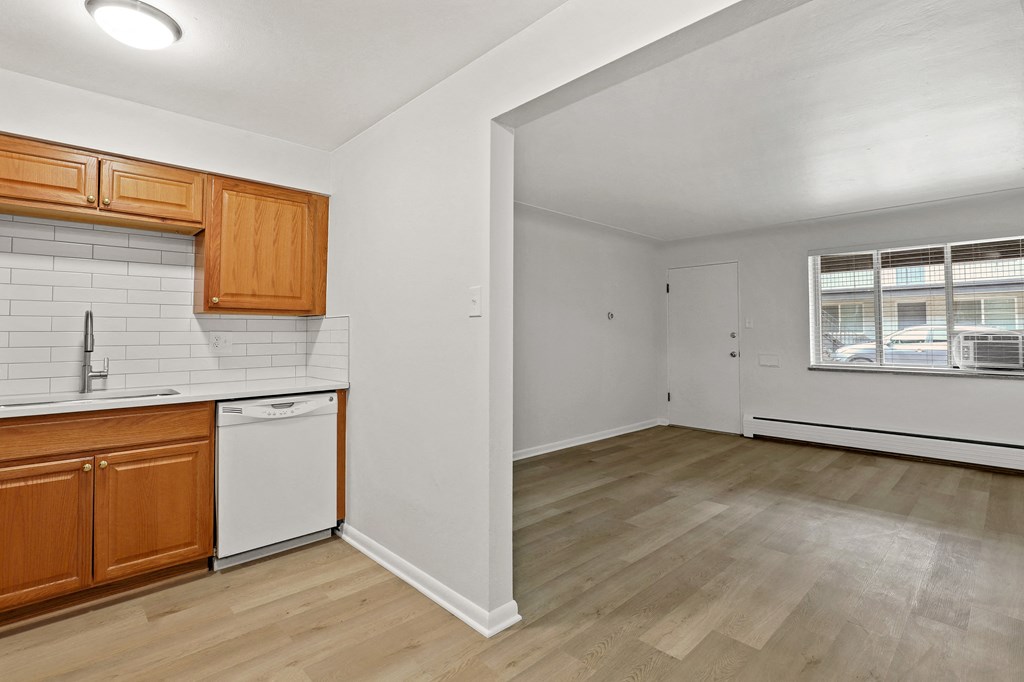 A kitchen with wooden cabinets and a white dishwasher.