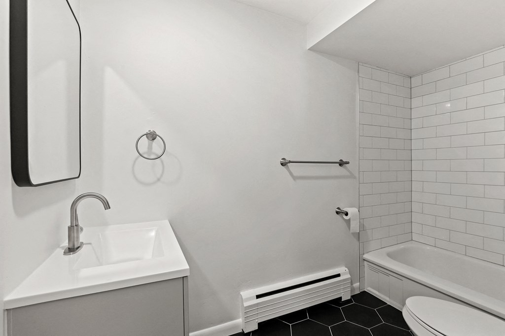 A white bathroom with a sink, toilet, and tub.