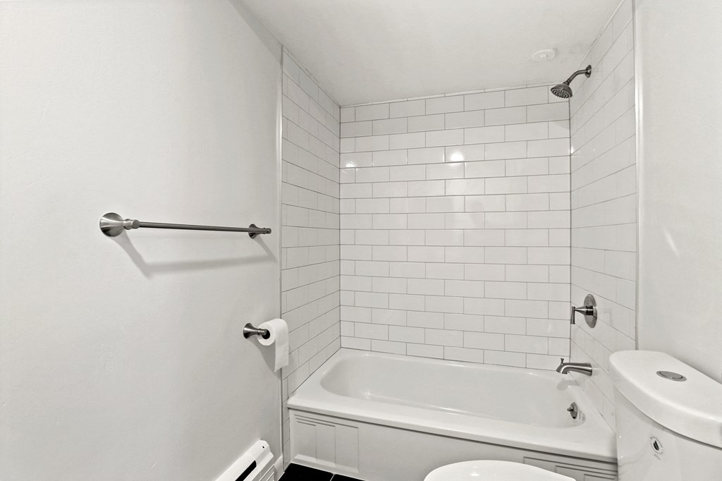 A white bathroom with a tub, toilet, and sink.