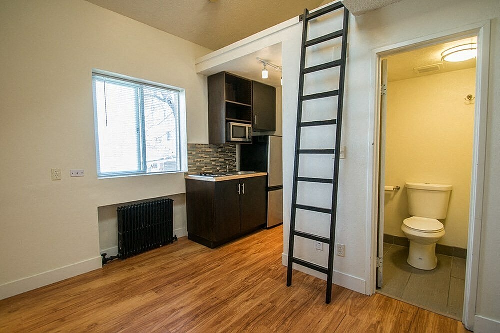 A room with a ladder and a toilet.
