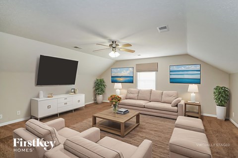 A living room with a large couch and a flat screen TV.