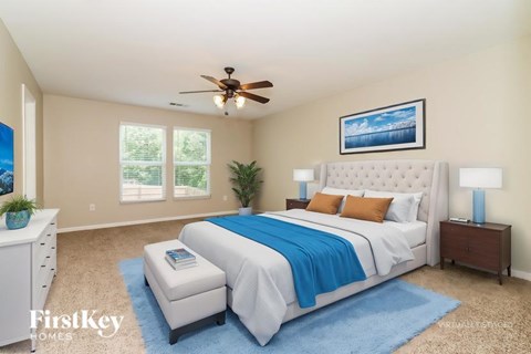 A bedroom with a large bed and a ceiling fan.