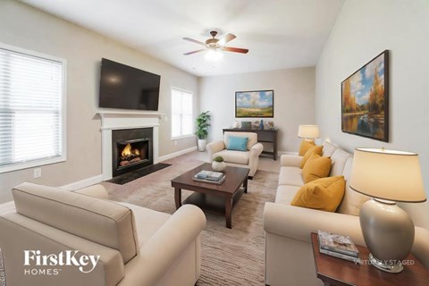 A living room with a fireplace and a flat screen TV.