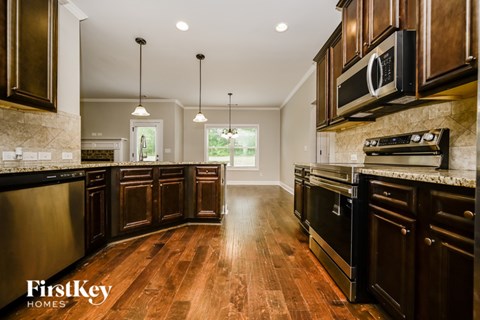 A kitchen with dark wood cabinets and a stainless steel oven.