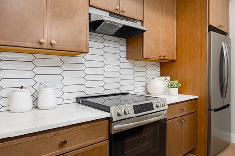 A kitchen with a stove top oven and a refrigerator.