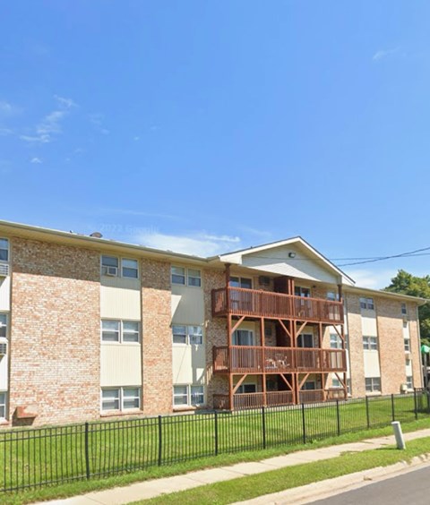 A brick building with a balcony on the second floor.