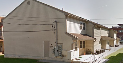 A beige house with a white door and a small window.