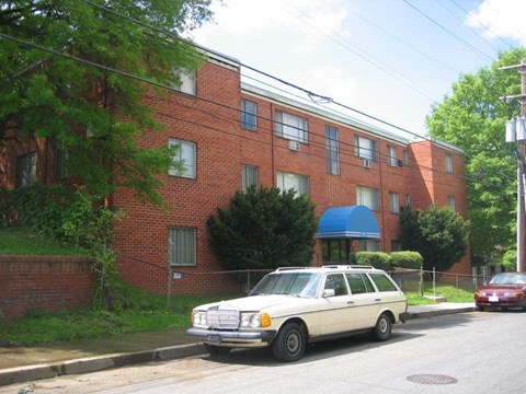A white station wagon is parked on the side of a street.