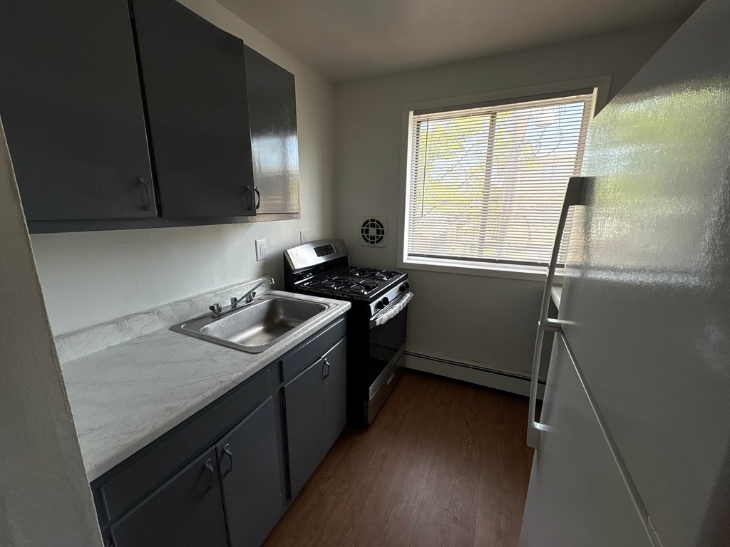 A small kitchen with a sink, stove, and refrigerator.