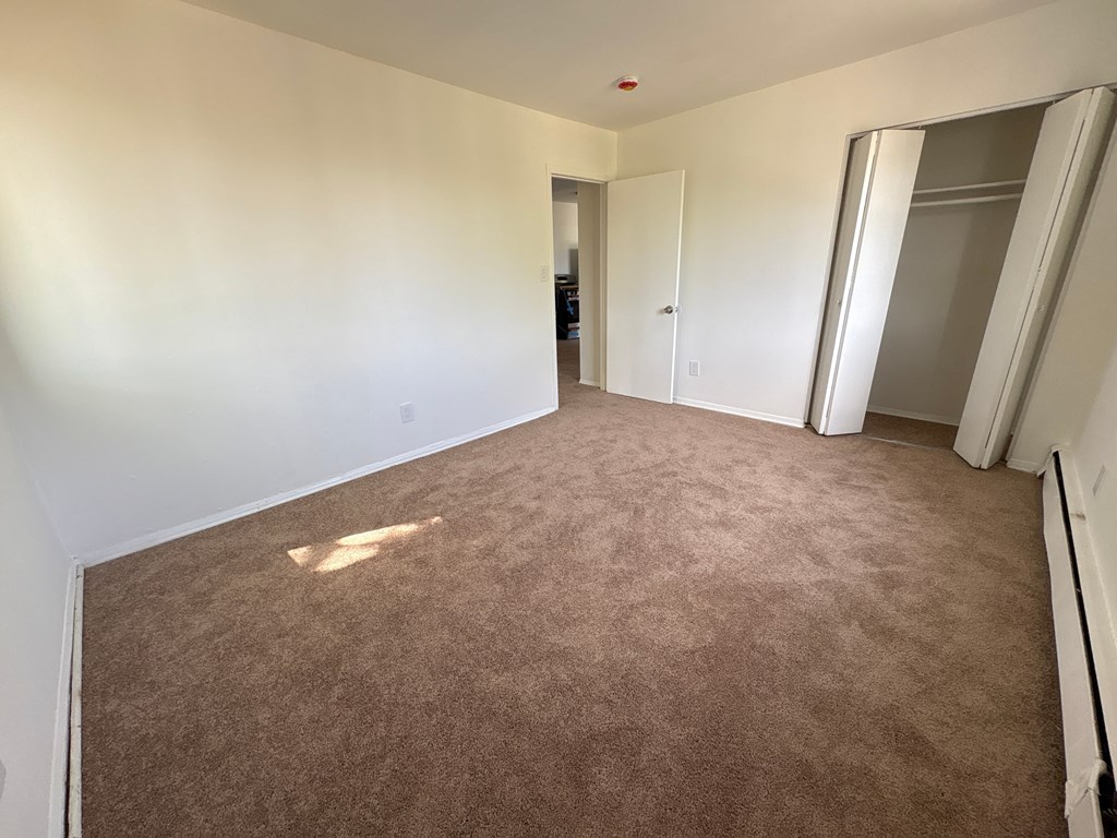 A room with brown carpet and white walls.